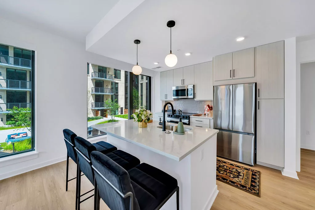 Contemporary kitchen with island seating, pendant lights, and stainless appliances.